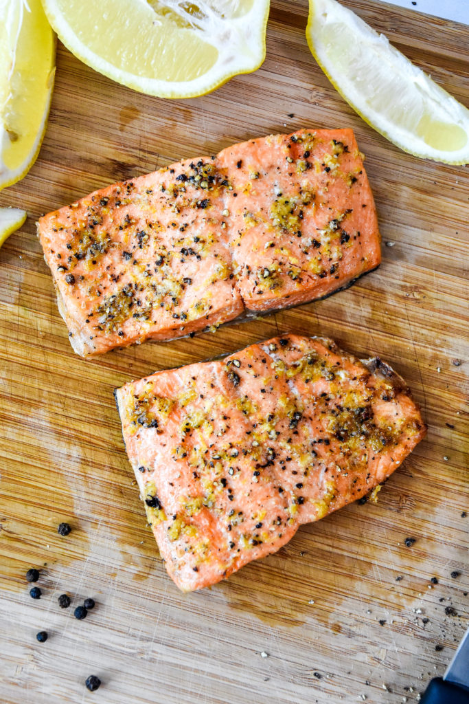 air fryer lemon pepper salmon filets on a cutting board.