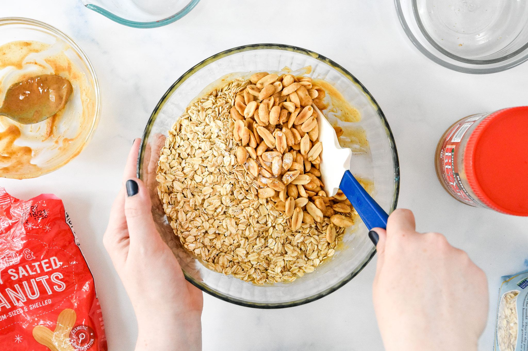 mixing oats and nuts into the wet ingredients to make the easy peanut butter granola.