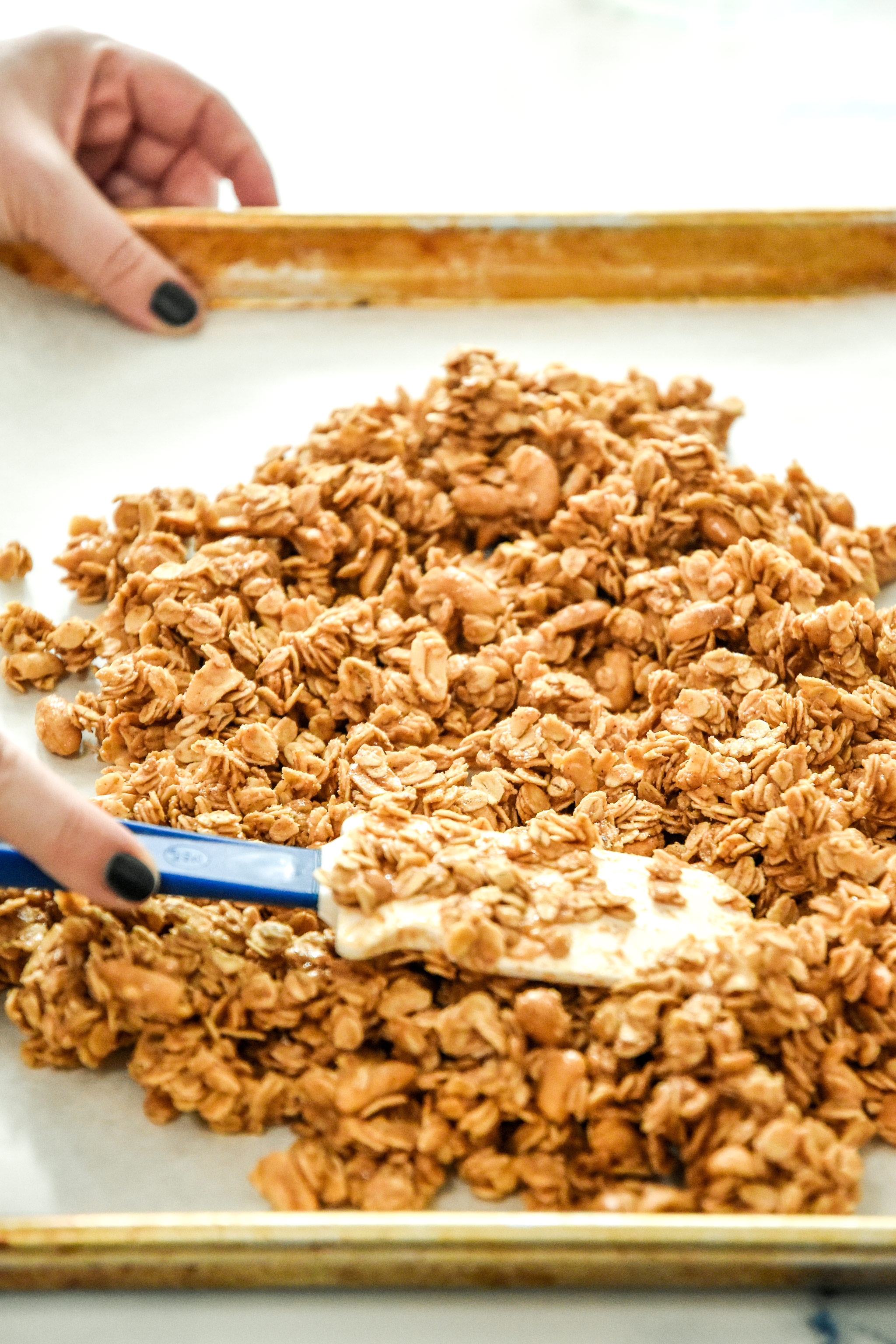 spreading the oat mixture out on the sheet pan.