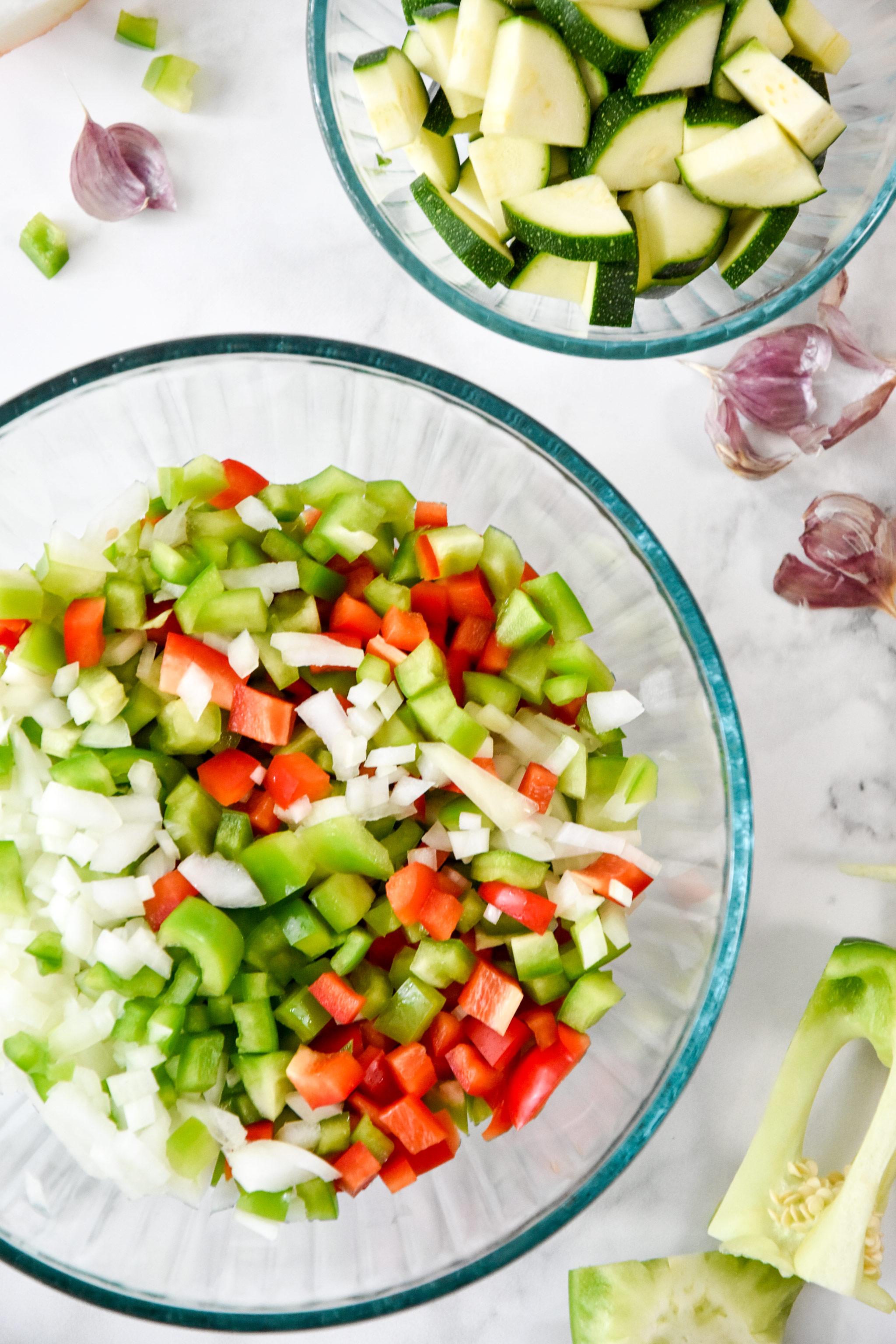 fresh cut peppers, onions, and zucchini in glass bowls for the meal prep recipe.