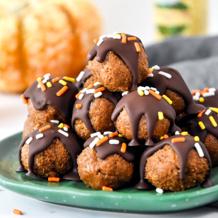no-bake pumpkin pie date balls stacked on a green plate.