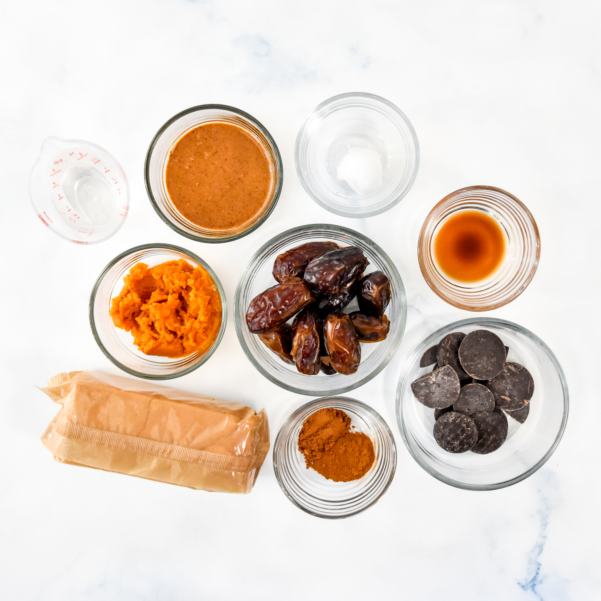ingredients for the no bake pumpkin pie date balls on a marble counter.