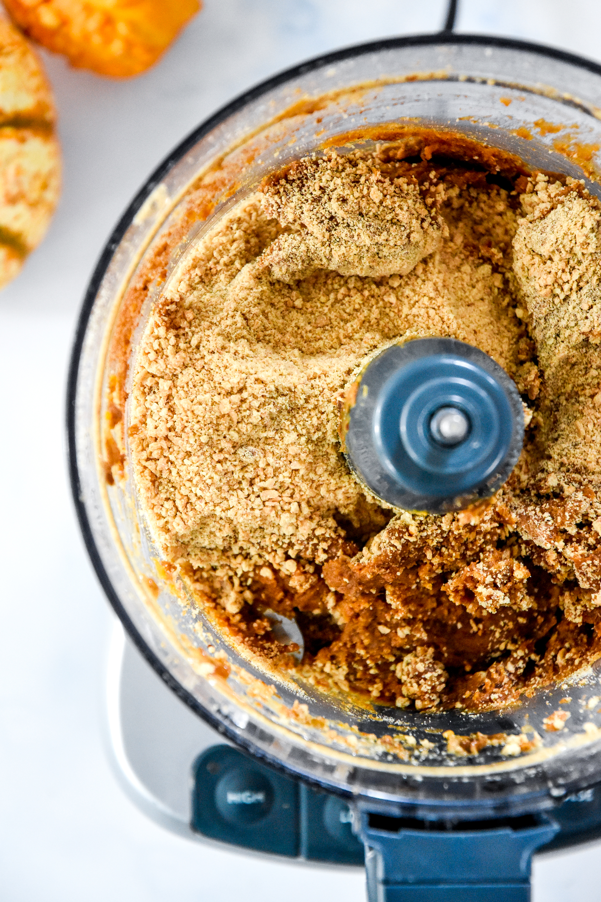 adding the graham cracker crumbs to the food processor.