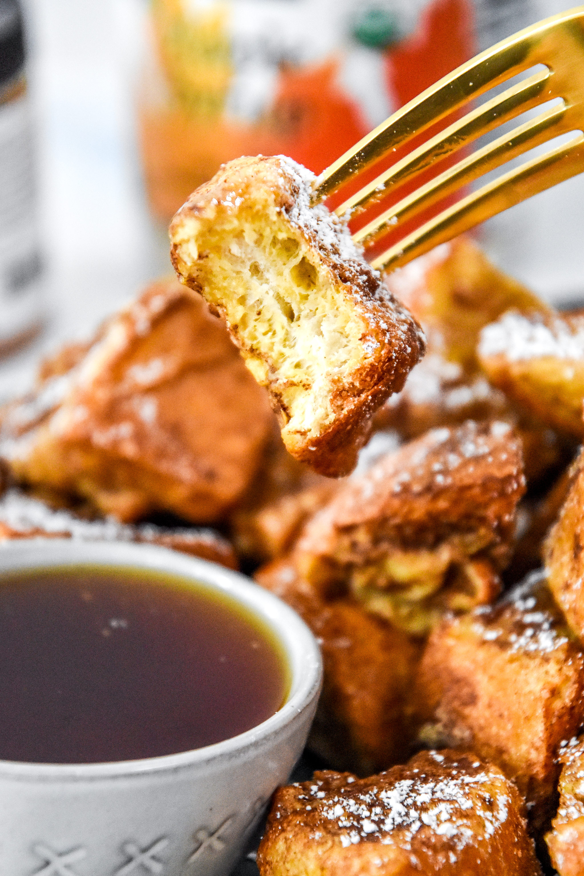 a bite taken out of a french toast bite on a fork.