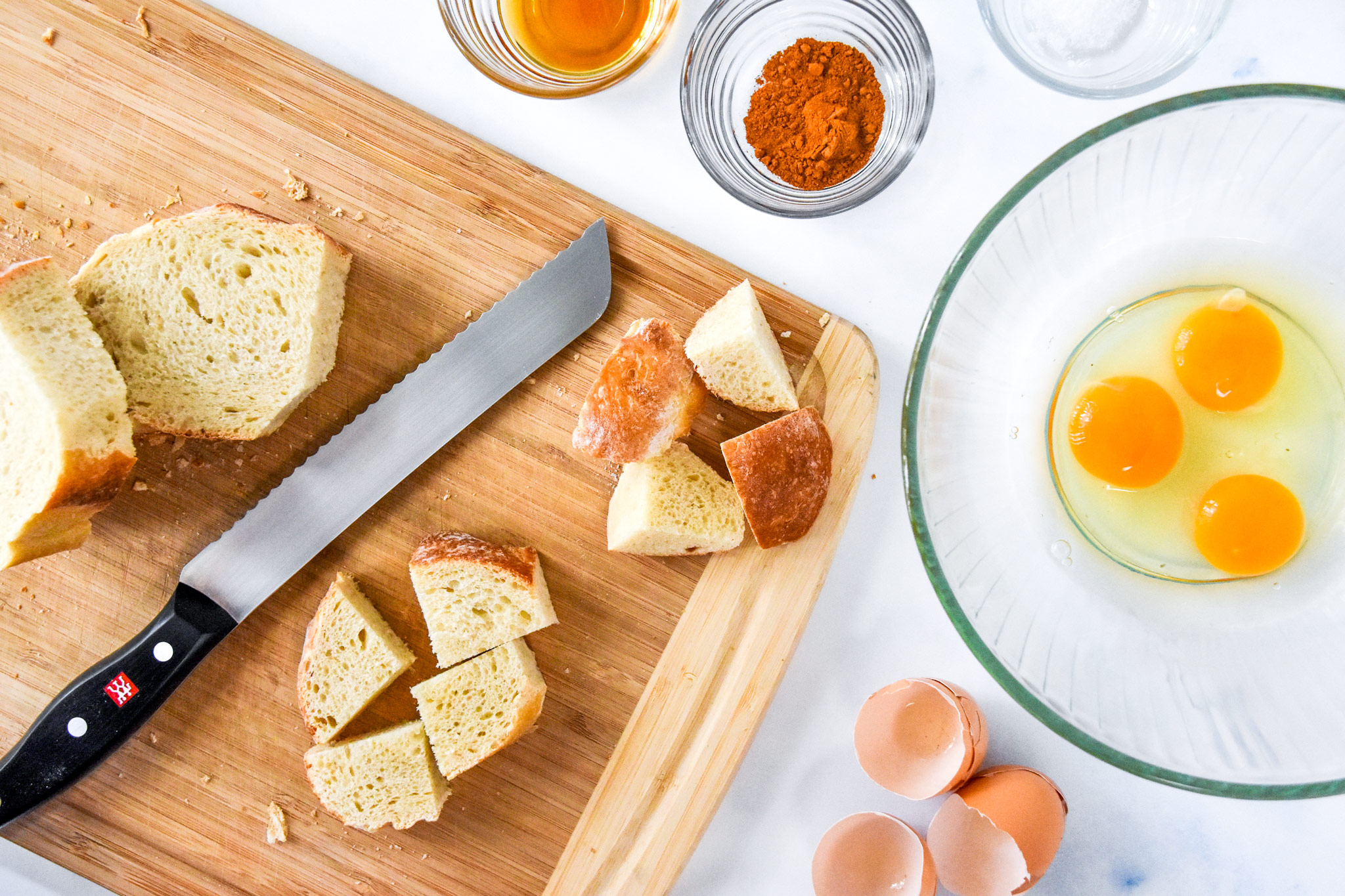 cutting the bread on a cutting board to make the french toast bites.