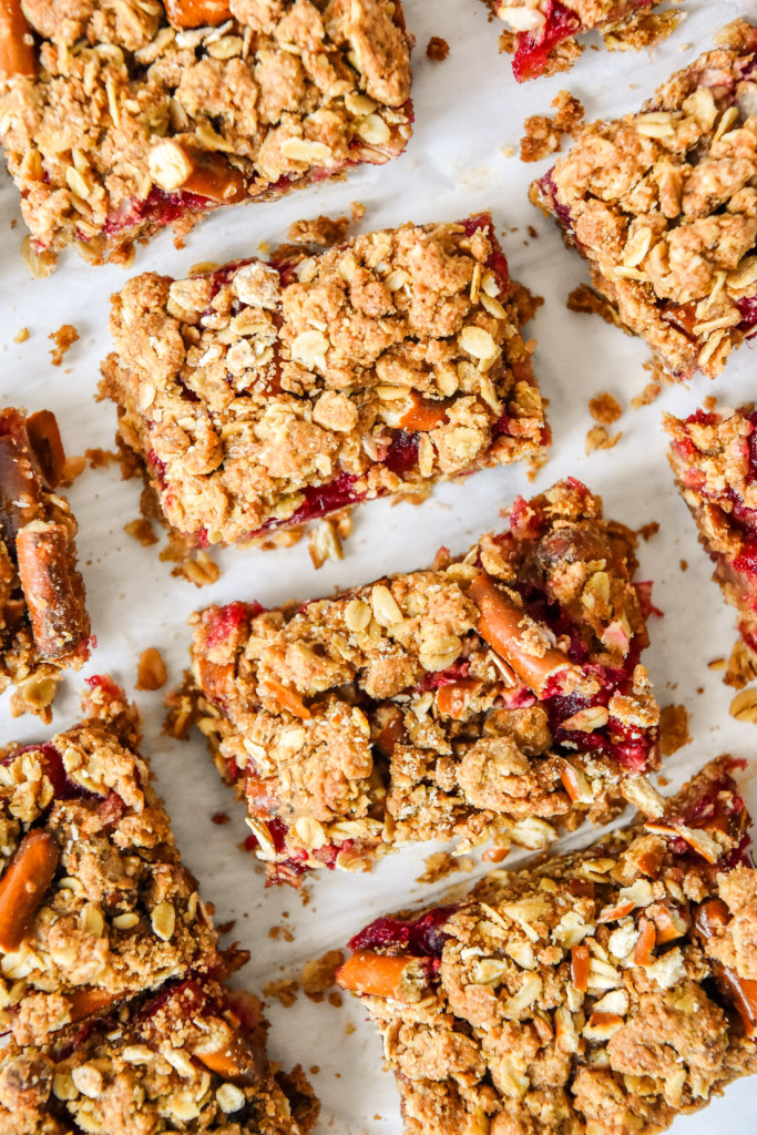 cranberry pretzel oat crumble bars cut on parchment paper.
