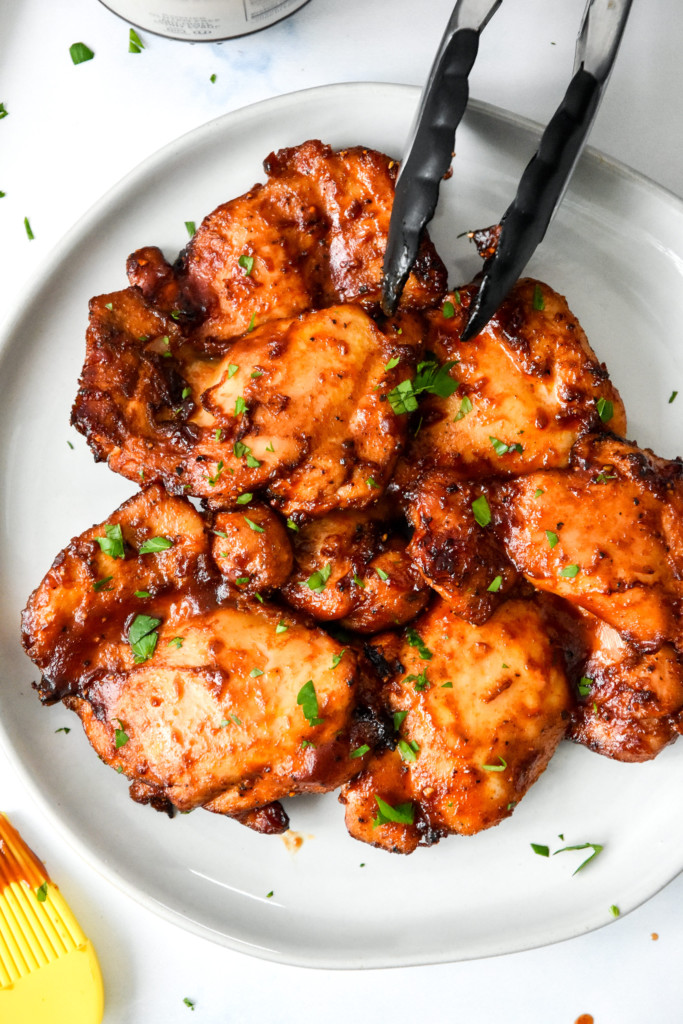 cooked air fryer boneless bbq chicken thighs on a plate.