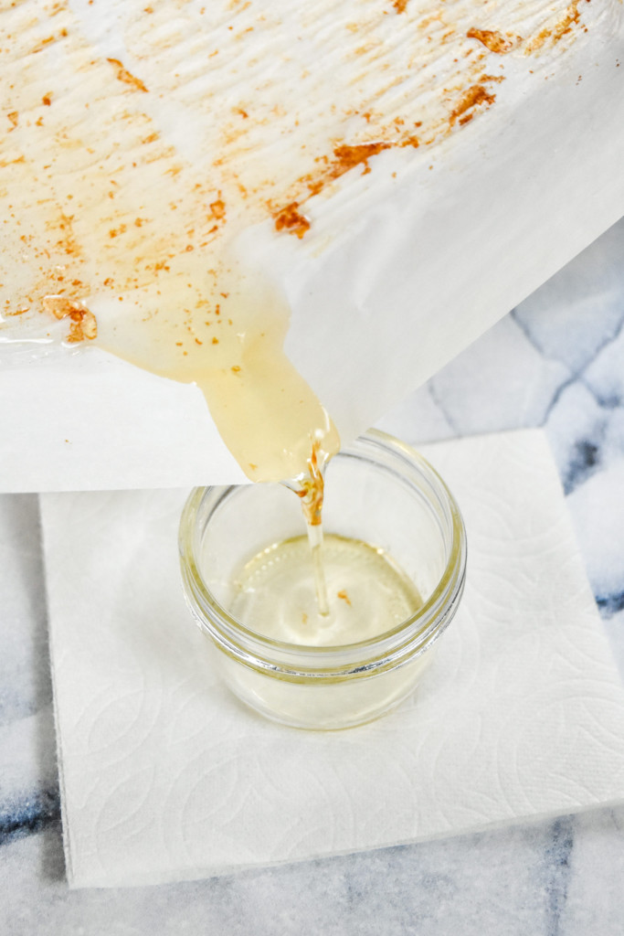 draining rendered bacon fat into a mason jar.