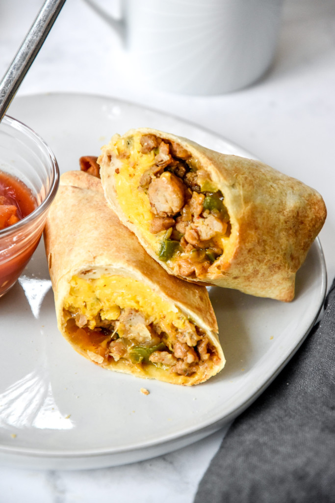 make ahead freezer friendly breakfast burrito cut in half on a plate.