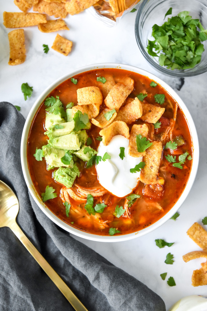 bowl of instant pot no bean chicken chili with sour cream, avocado and corn chips on top.