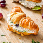 easy chicken salad with grapes on a croissant on a cutting board.
