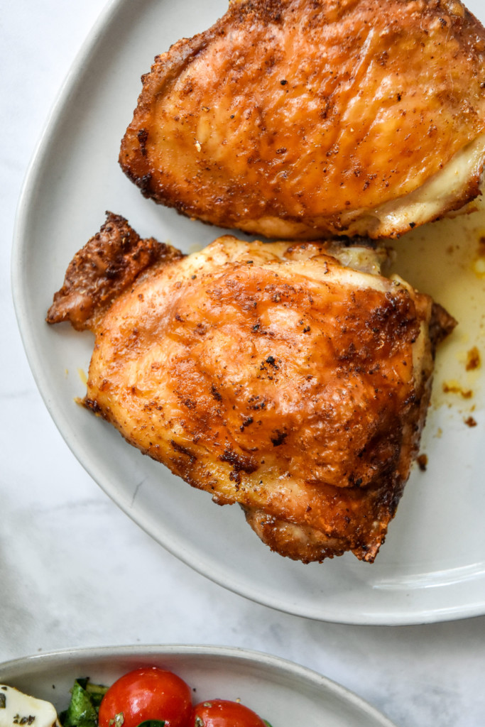crispy chicken thigh with skin on a plate.