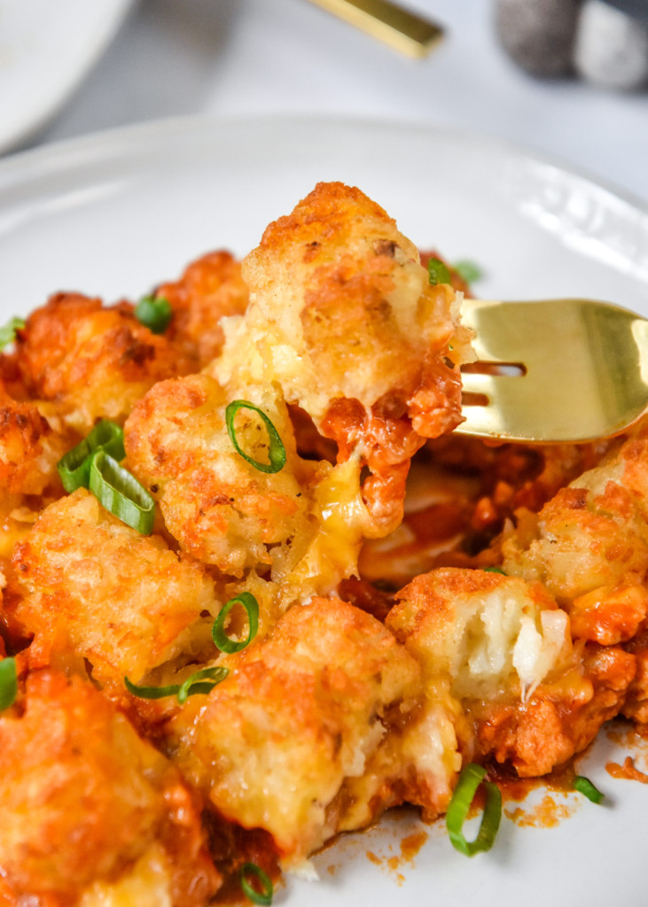 a bite of turkey sloppy joe tater tot casserole on a gold fork.
