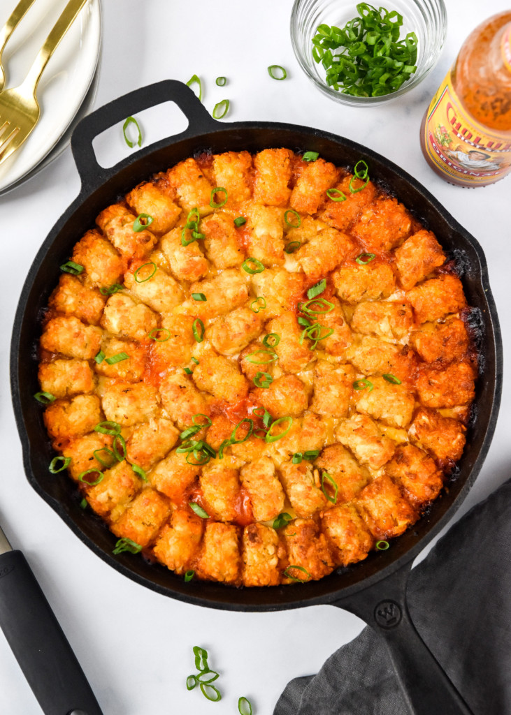 turkey sloppy joe tater tot casserole cooked in a cast iron on a table.