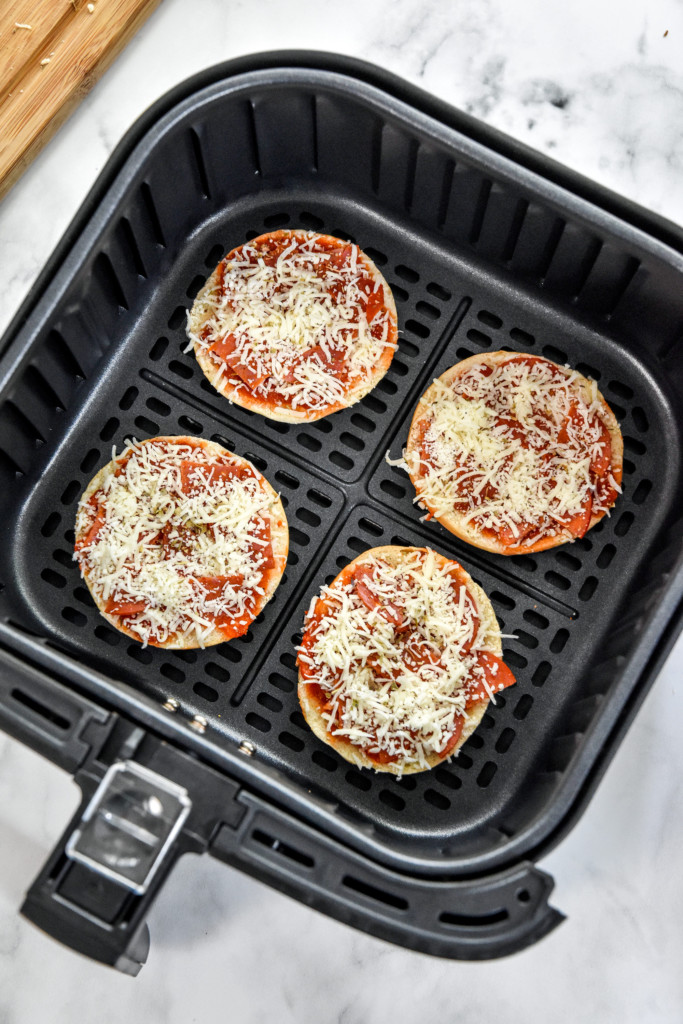 assembled air fryer homemade pizza bagel bites in the air fryer basket.