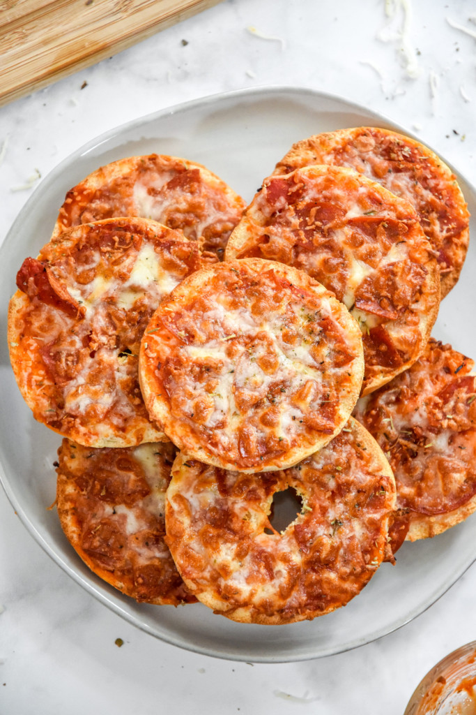 air fryer homemade pizza bagel bites stacked on a plate.