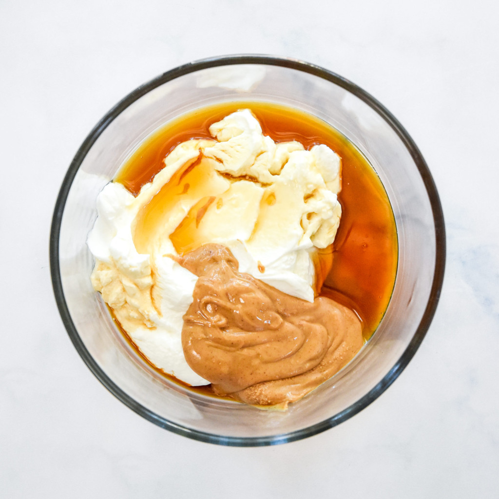 ingredients in a glass bowl before mixing up the fruit dip.