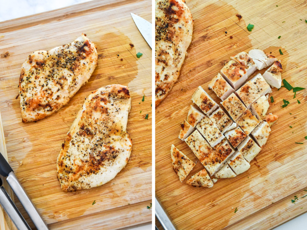 dicing up the cooked chicken breasts on a cutting board.