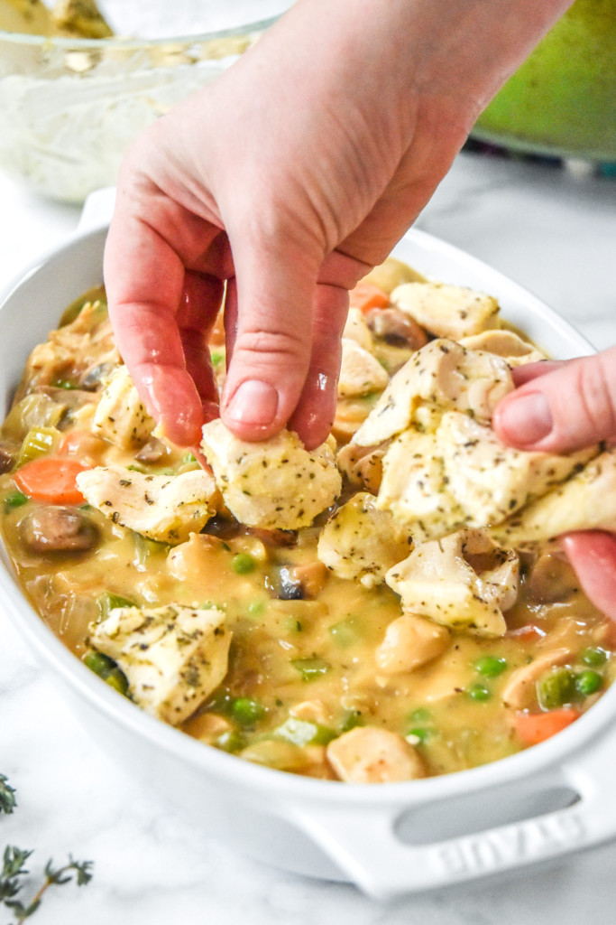 placing the biscuit pieces on the pot pie filling.