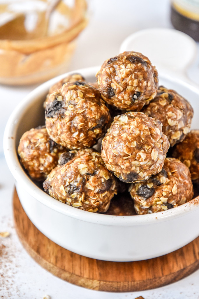 no-bake oatmeal raisin cookie balls stacked in a white bowl.