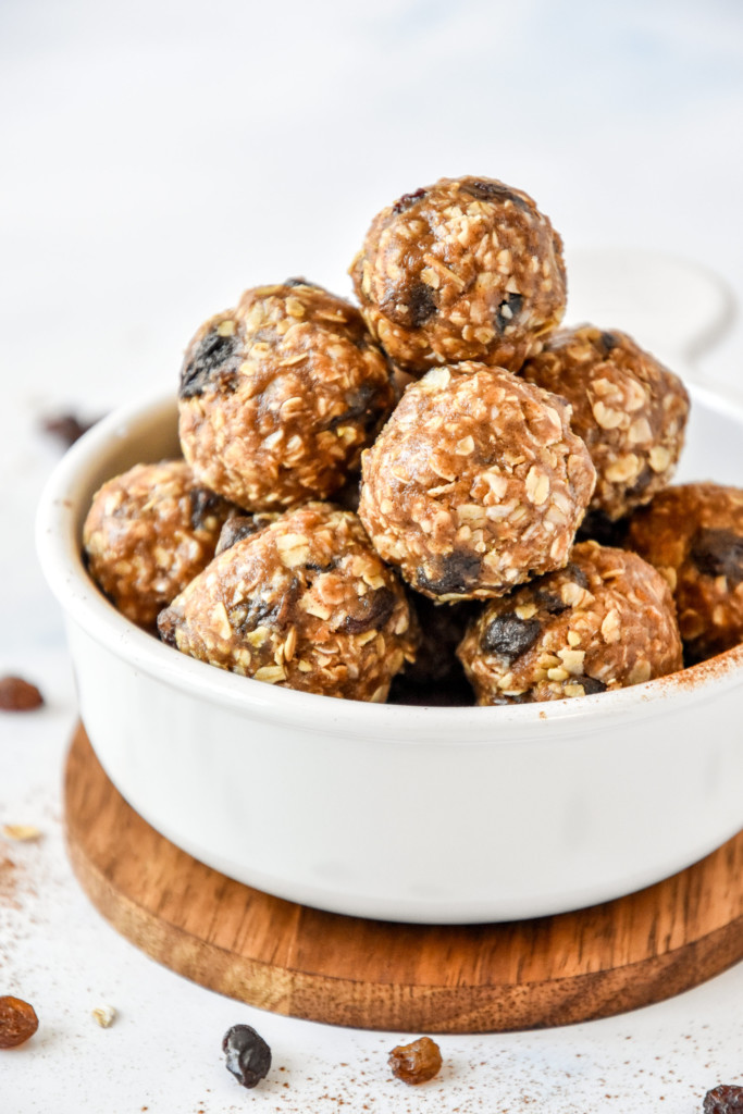 no-bake oatmeal raisin cookie balls stacked in a white bowl.