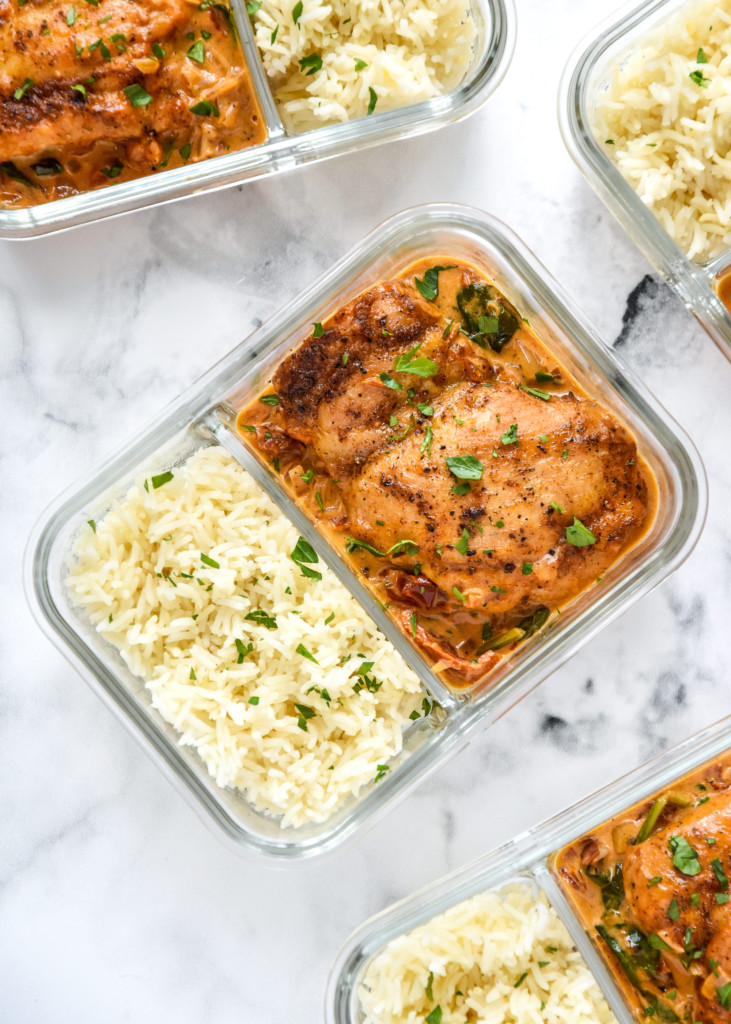 creamy tuscan chicken meal prep with rice in a glass meal prep container.