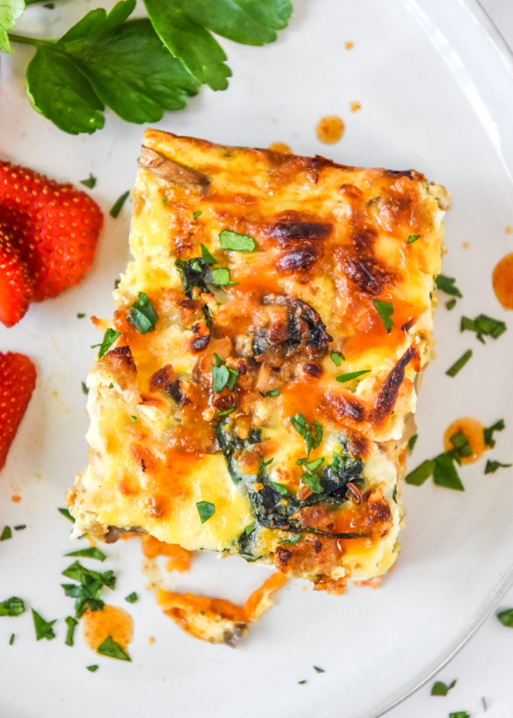 a slice of breakfast casserole with hot sauce.