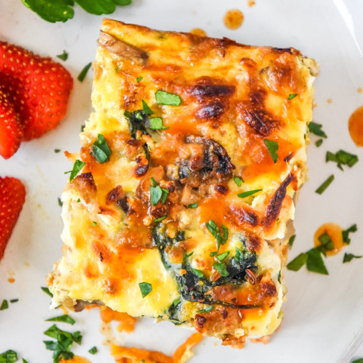 a slice of breakfast casserole with hot sauce.