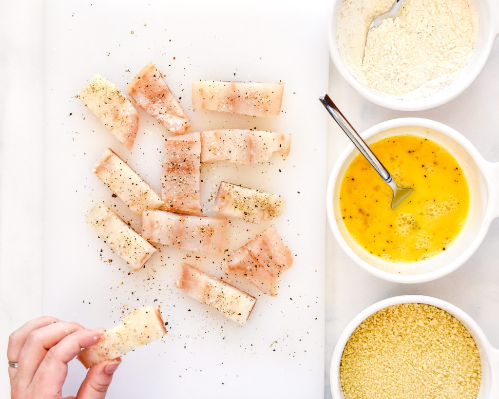 cut fish seasoned and ready to be breaded.