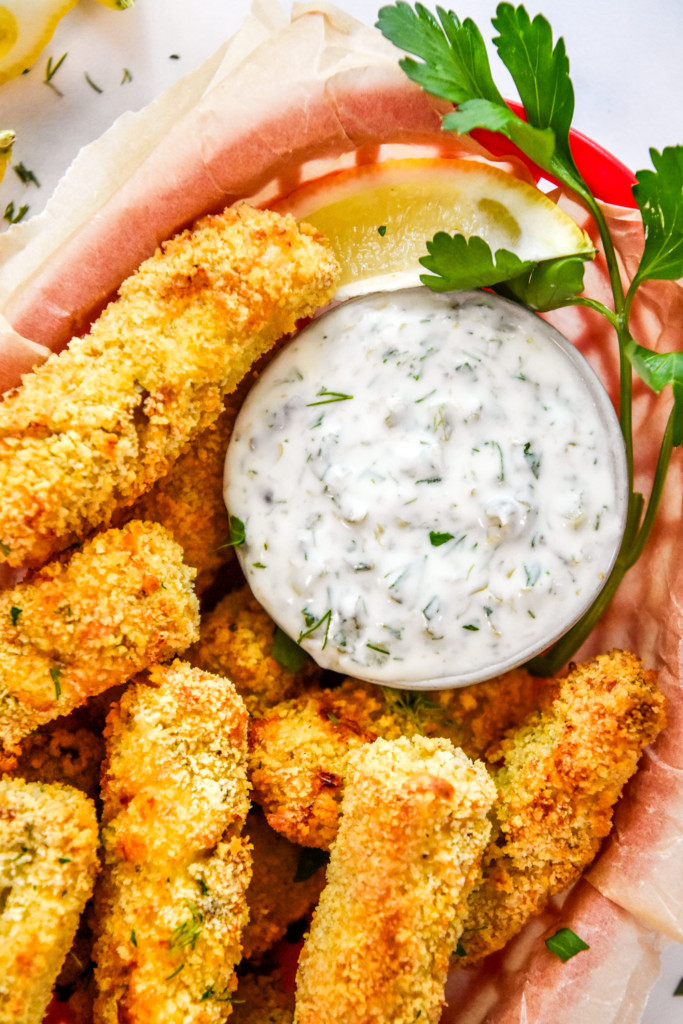 close up of the yogurt tartar sauce in a basket of fish sticks.