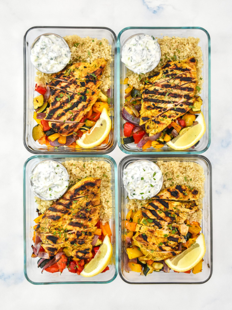 four portions of indian-inspired spiced chicken meal prep in glass bowls.