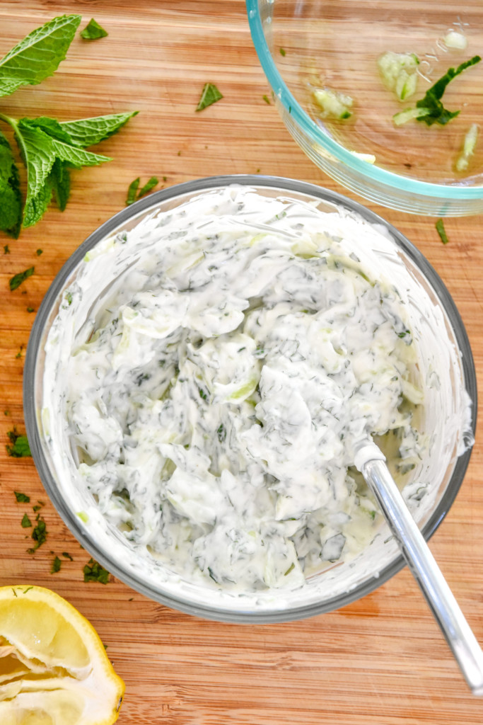 cucumber raita mixed in a glass pyrex for the indian-inspired spiced chicken meal prep.