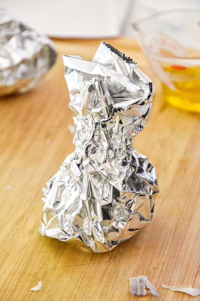 head of garlic wrapped in foil for how to roast garlic in an air fryer.