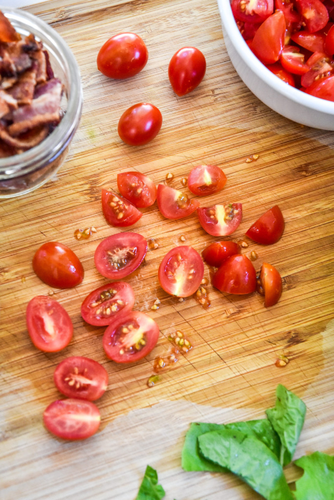 cutting up tomatoes on a cutting board.