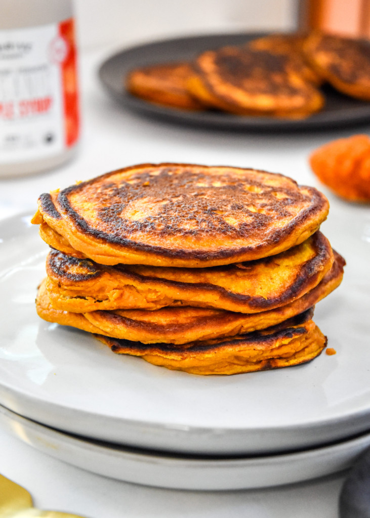 pumpkin pie greek yogurt pancakes stacked on a plate.
