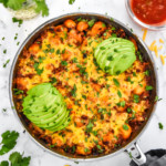 one-pan soy chorizo gnocchi skillet with avocado and cilantro on top.