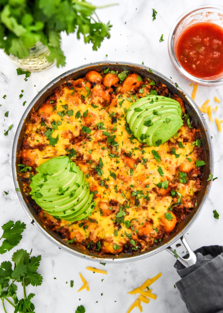 one-pan soy chorizo gnocchi skillet with avocado and cilantro on top.