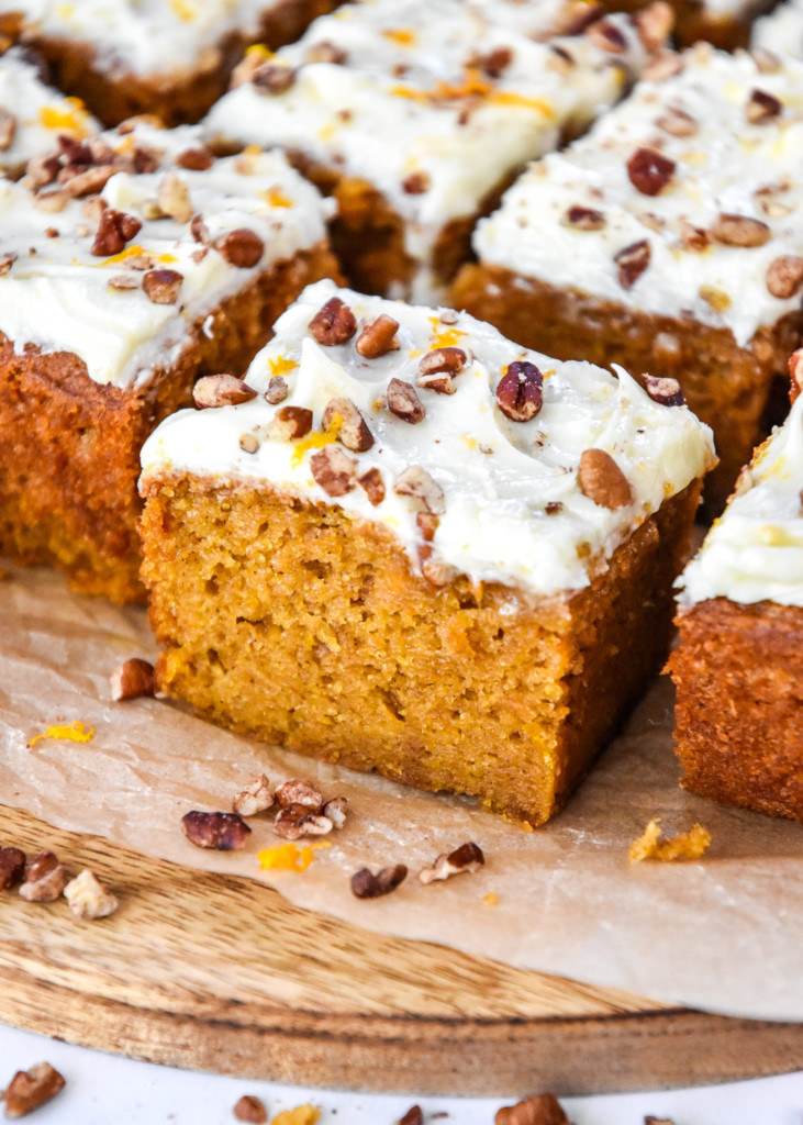 sweet potato spice cake with cream cheese frosting and chopped pecans on top.