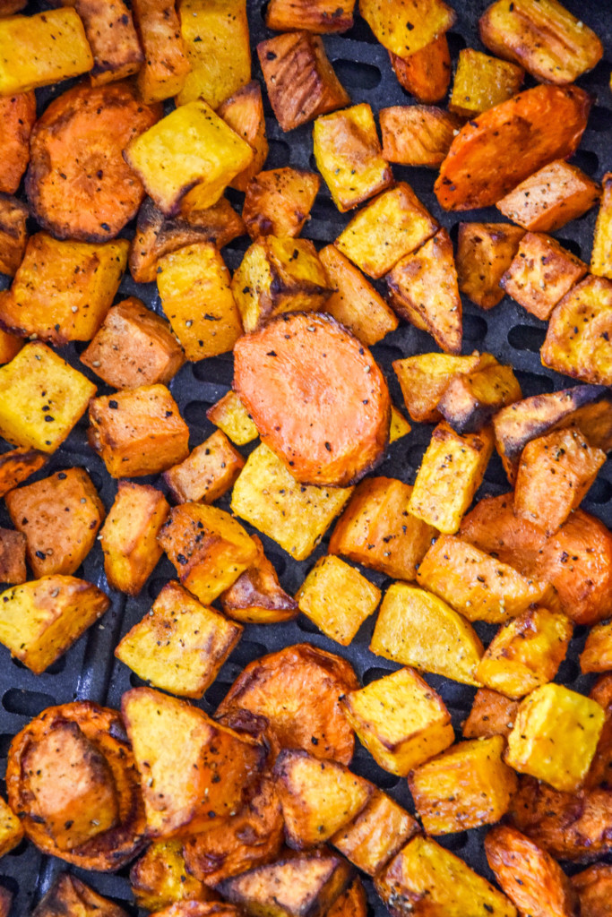 cooked air fryer roasted fall vegetables in the air fryer basket.