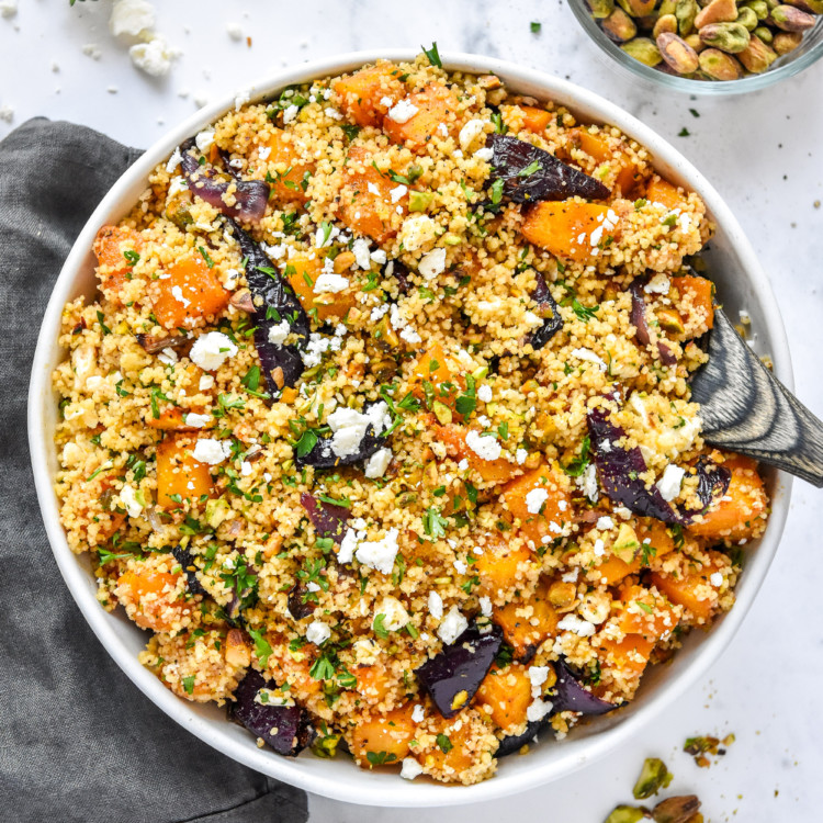 bowl of Roasted Butternut Squash Couscous Salad with a wooden spoon.