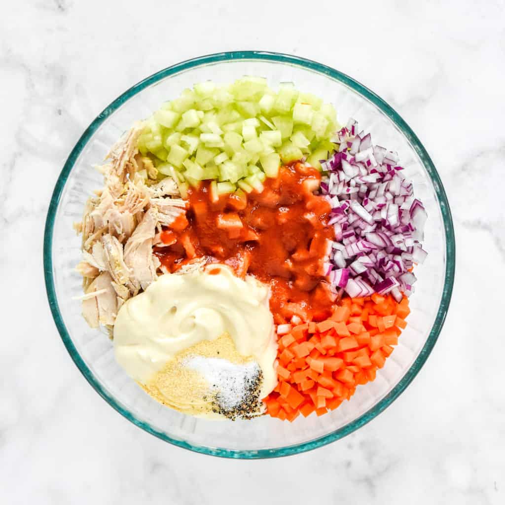 ingredients in a mixing bowl before mixing up the buffalo chicken salad.