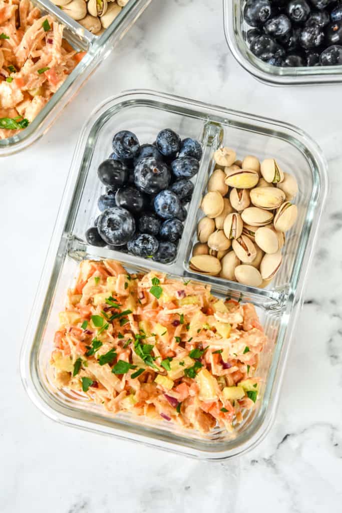 close up of easy buffalo chicken salad meal in a glass meal prep bowl.