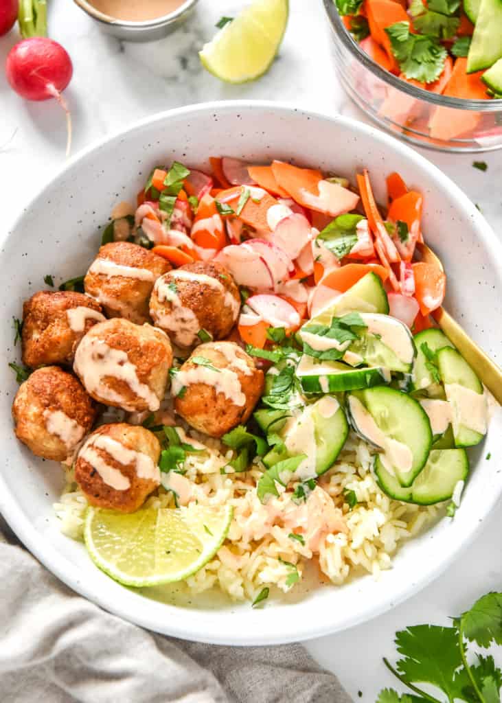 banh mi inspired meal prep bowls with spicy mayo sauce drizzled on top.