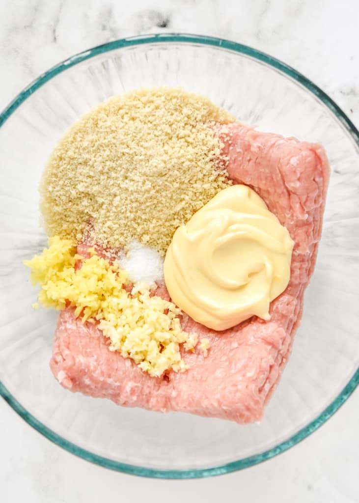 ingredients for the meatball mixture in a large glass bowl before mixing together.