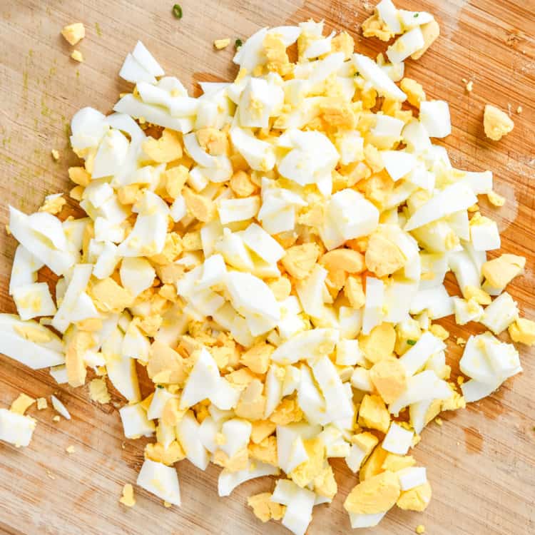 chopped hard boiled eggs on a cutting board for egg salad.