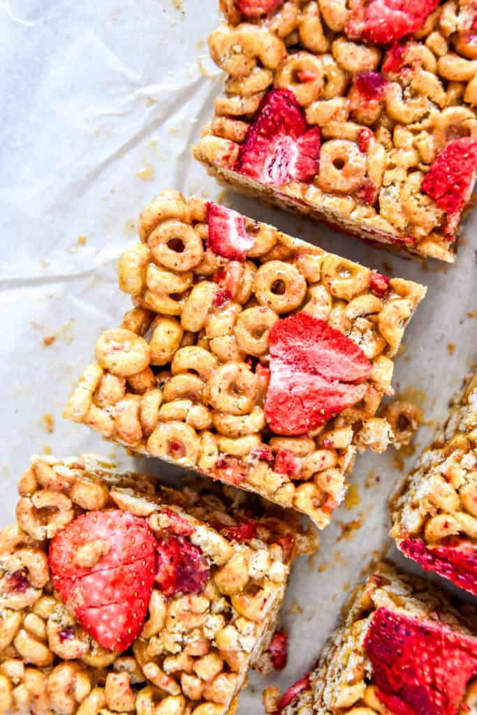 strawberry peanut butter cheerios bars cut on parchment paper.