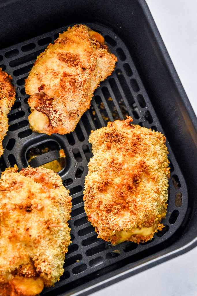 cooked air fryer chicken cordon bleu in the air fryer basket.