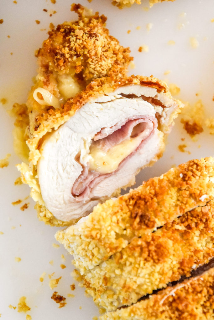 sliced air fryer chicken cordon bleu with gruyere and ham inside.