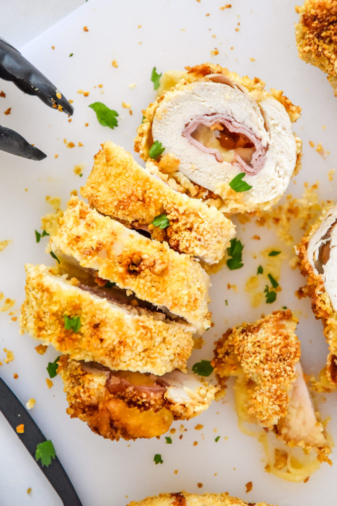 sliced air fryer chicken cordon bleu on a cutting board.