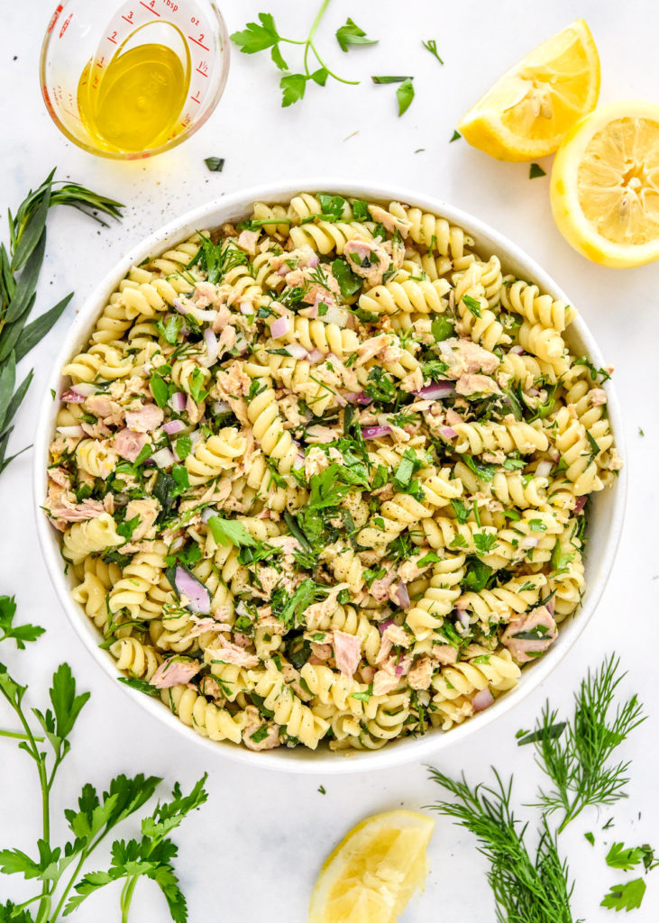 lemon vinaigrette tuna pasta salad with fresh herbs in a serving bowl.